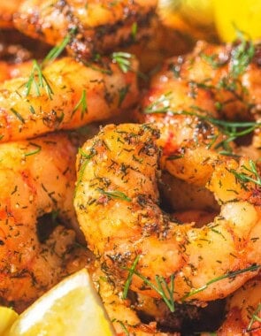 Air fryer shrimp with lemon wedges.