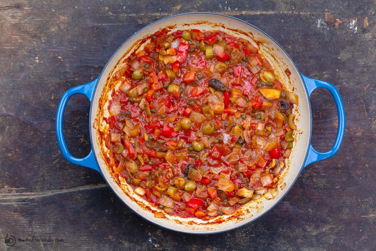 tomato sauce, olives and the remaining ingredients are added to the pan