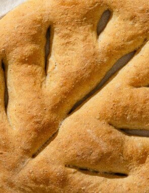 A close up of baked fougasse on a kitchen towel.