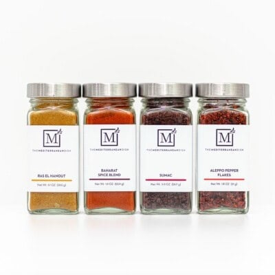 Bottles of ras el hanout, baharat spice blend, sumac, and aleppo pepper flakes from the mediterranean dish.