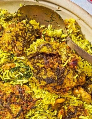 The baghali polo on a platter with a spoon.