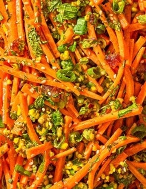 A close up of carrot salad with herbs.