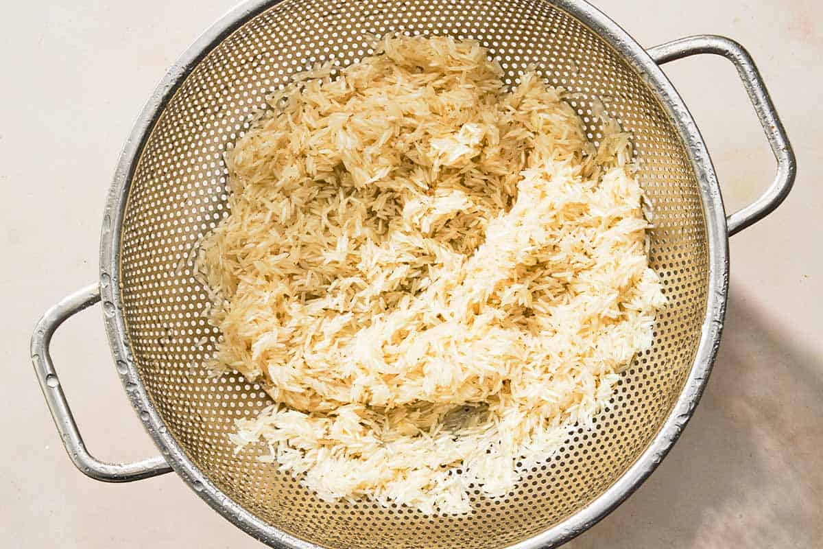 The rinsed rice for the turmeric rice in a colander.